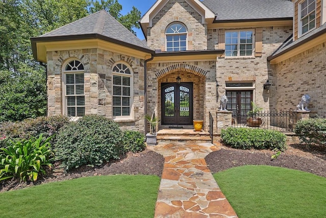 entrance to property with a yard and french doors