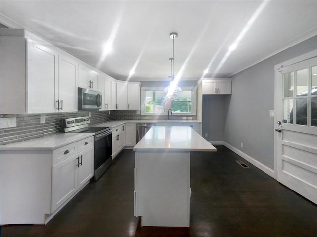 kitchen featuring white cabinetry, sink, hanging light fixtures, stainless steel appliances, and a kitchen island