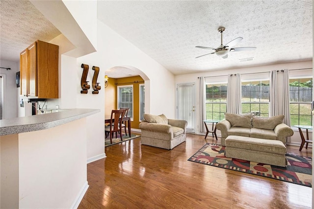 7057 Silver Bend Ovrlk, Austell, GA 30168 - living room featuring a textured ceiling, arched walkways, dark wood-type flooring, and ceiling fan