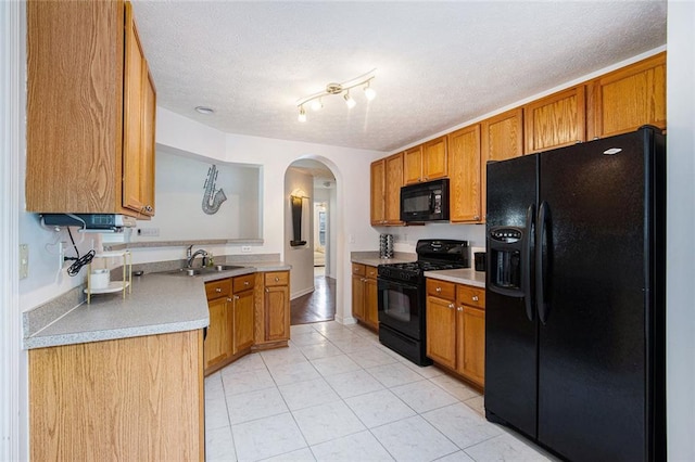 7057 Silver Bend Ovrlk, Austell, GA 30168 - kitchen featuring black appliances, arched walkways, light tile patterned flooring, brown cabinets, and a textured ceiling