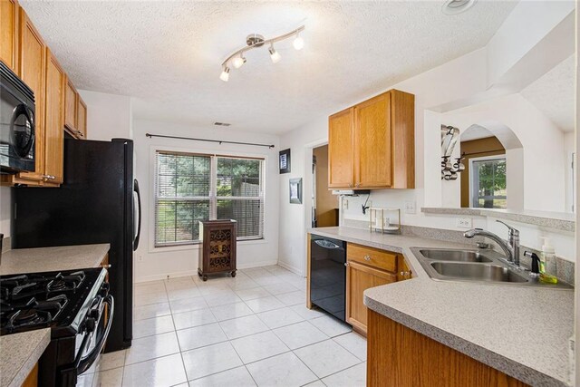 7057 Silver Bend Ovrlk, Austell, GA 30168 - kitchen featuring black appliances, plenty of natural light, light tile patterned floors, brown cabinets, and a textured ceiling
