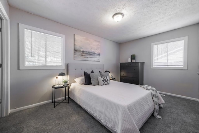 carpeted bedroom featuring multiple windows, a textured ceiling, and baseboards