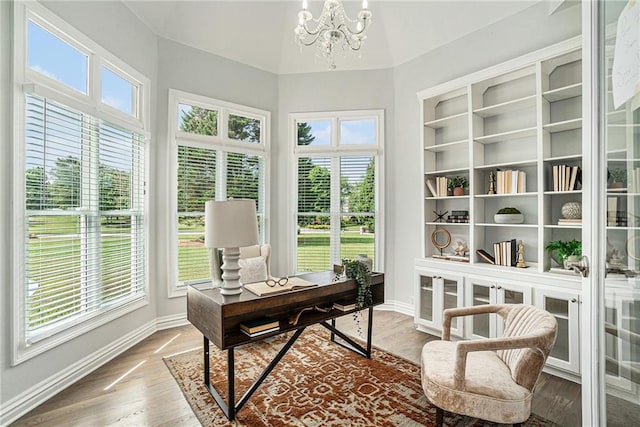 office area featuring a chandelier, baseboards, and wood finished floors