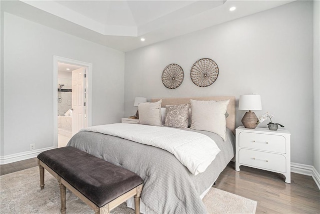 bedroom with recessed lighting, wood finished floors, baseboards, and ensuite bathroom