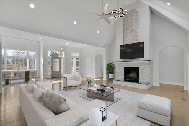 living area with ceiling fan, recessed lighting, a fireplace, wood finished floors, and arched walkways