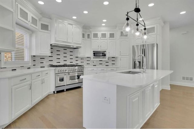 kitchen featuring visible vents, a sink, stainless steel appliances, light countertops, and white cabinets