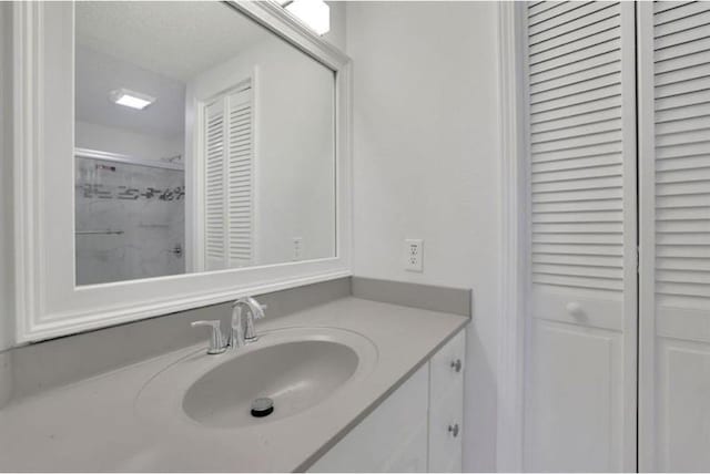 bathroom featuring a closet, a textured ceiling, and vanity