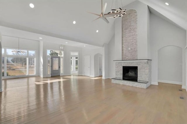 unfurnished living room with high vaulted ceiling, a fireplace, recessed lighting, ceiling fan, and wood finished floors