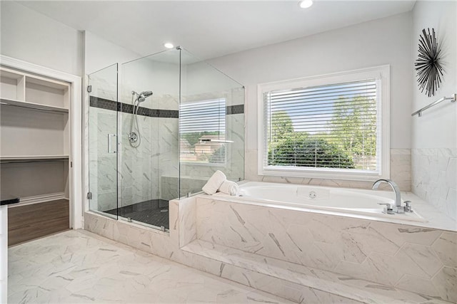 full bathroom with a marble finish shower, marble finish flooring, a garden tub, a spacious closet, and recessed lighting