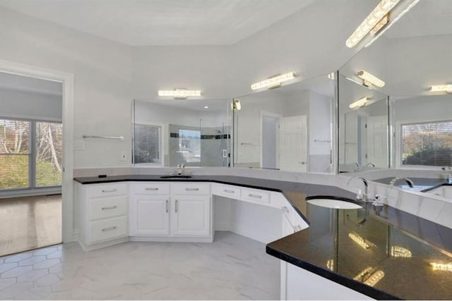 full bathroom featuring a sink, a shower with door, and marble finish flooring