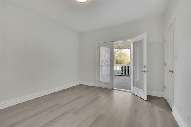 empty room with light wood-type flooring and baseboards