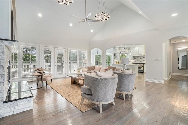 living room featuring arched walkways, high vaulted ceiling, ceiling fan, plenty of natural light, and recessed lighting