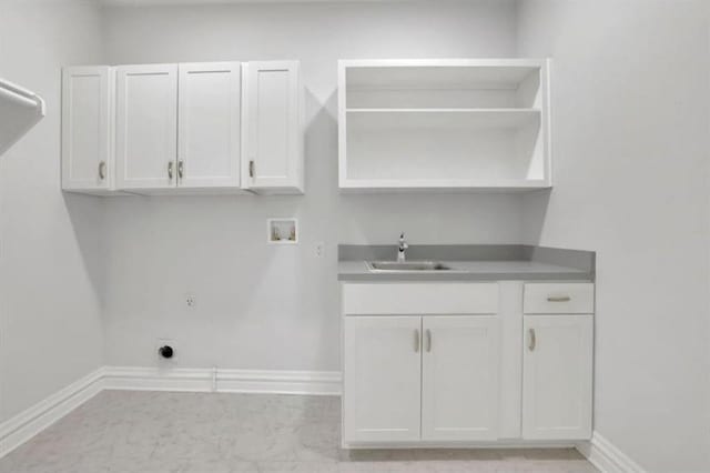 laundry room with baseboards, hookup for an electric dryer, cabinet space, a sink, and washer hookup