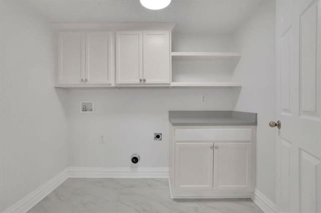 laundry area featuring washer hookup, light marble finish floors, hookup for an electric dryer, and baseboards