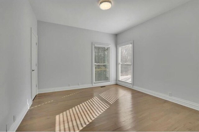 unfurnished room with wood finished floors and baseboards
