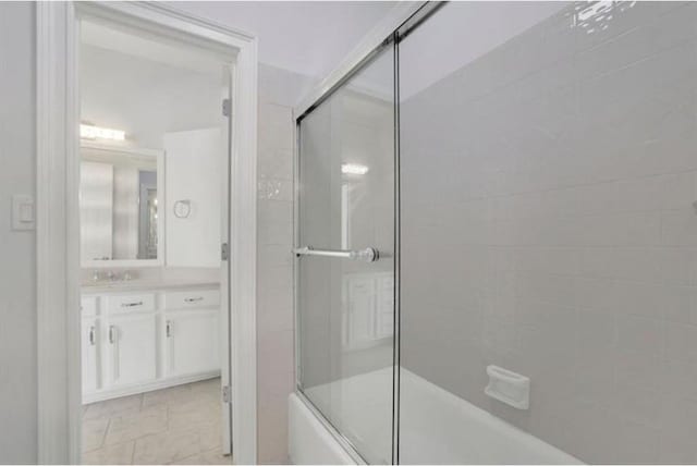bathroom featuring vanity, marble look tile flooring, and shower / bath combination with glass door