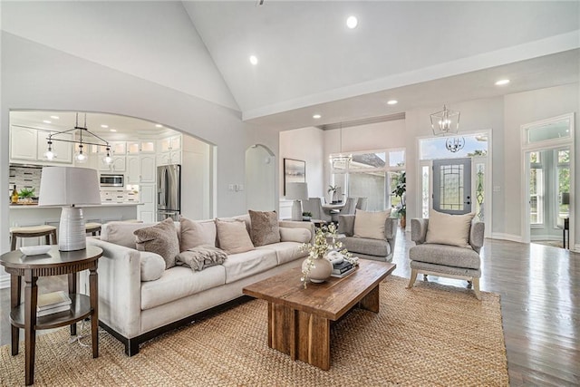 living area featuring recessed lighting, light wood-style floors, a chandelier, arched walkways, and high vaulted ceiling