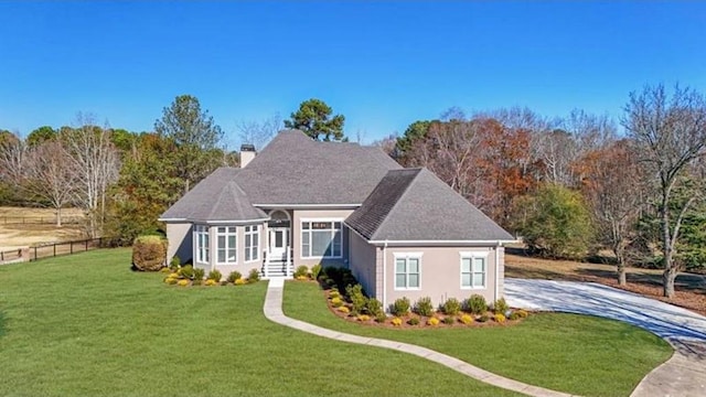 view of front of property with a chimney, a front lawn, and fence