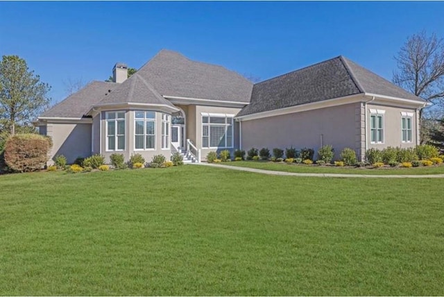 back of house featuring stucco siding, a lawn, and a chimney