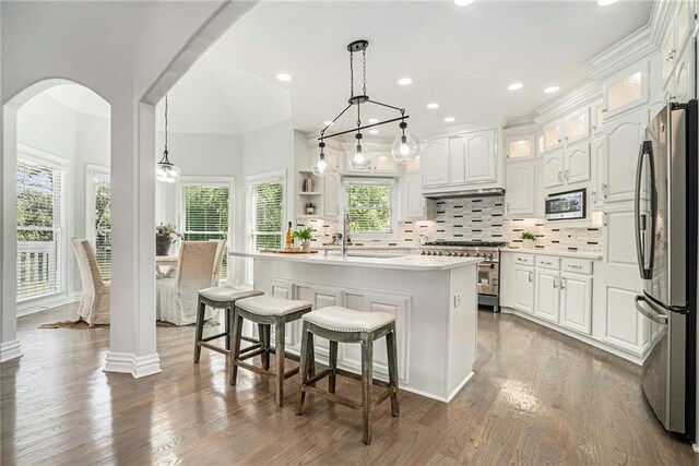 kitchen featuring stainless steel appliances, white cabinets, backsplash, a sink, and recessed lighting