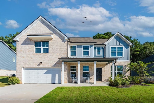 view of front of home featuring a front lawn, covered porch, and a garage