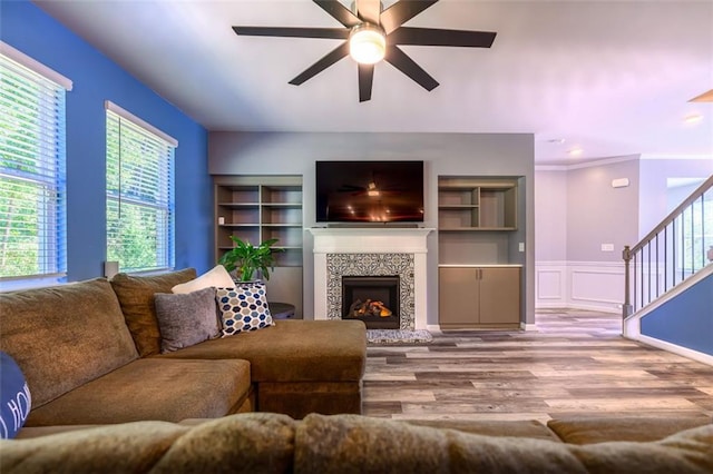 living room with ceiling fan, light hardwood / wood-style flooring, a fireplace, and crown molding