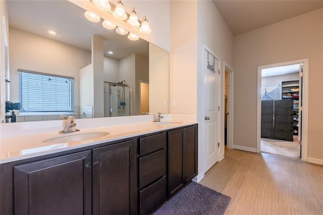 bathroom featuring wood-type flooring, vanity, and a shower with shower door