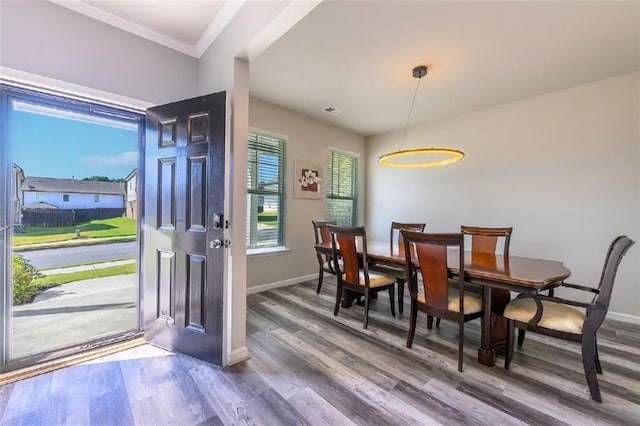 dining space featuring hardwood / wood-style flooring and crown molding