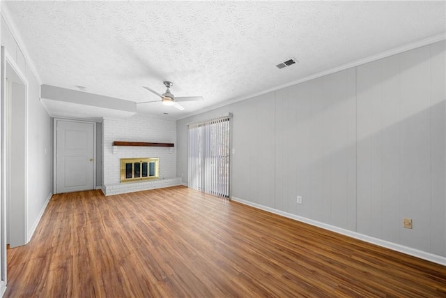 4347 Pleasant Ridge Rd, Decatur, GA 30034 - unfurnished living room featuring a brick fireplace, wood finished floors, visible vents, and a ceiling fan