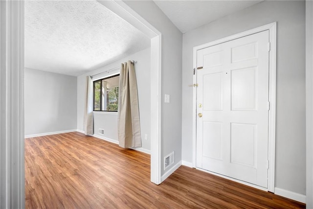 4347 Pleasant Ridge Rd, Decatur, GA 30034 - foyer with a textured ceiling, wood finished floors, visible vents, and baseboards