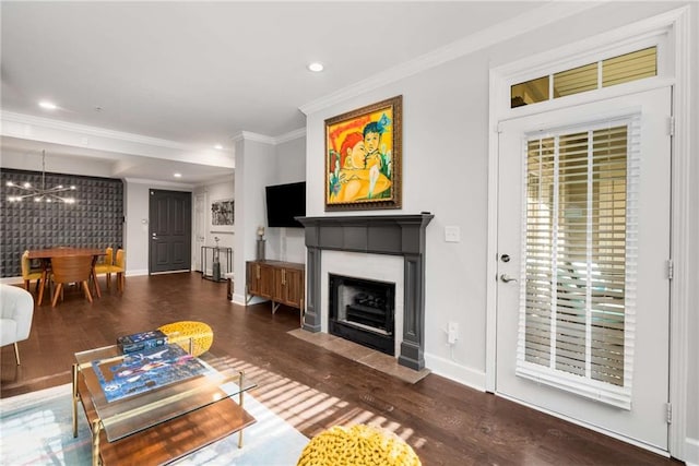 living room featuring dark hardwood / wood-style flooring, crown molding, and a chandelier