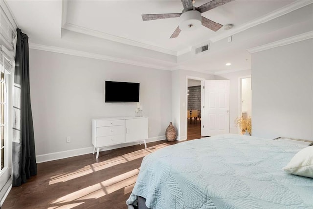 bedroom featuring ceiling fan, crown molding, hardwood / wood-style flooring, and a tray ceiling