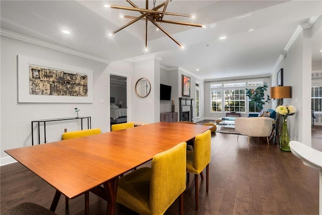 dining area featuring dark wood-type flooring, ornamental molding, and a notable chandelier