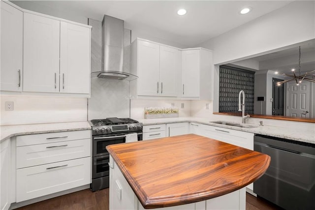 kitchen with double oven range, white cabinets, dishwasher, and wall chimney exhaust hood