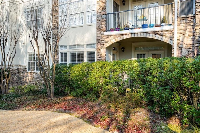 view of exterior entry with a balcony