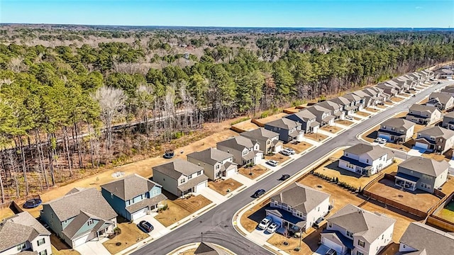 drone / aerial view with a residential view and a view of trees