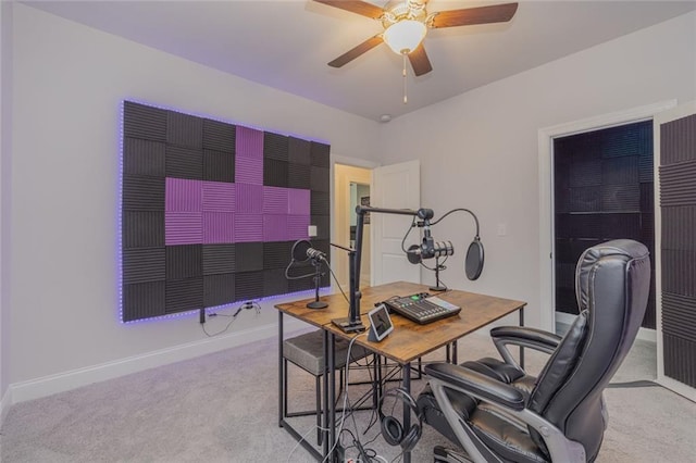 home office with baseboards, a ceiling fan, and light colored carpet