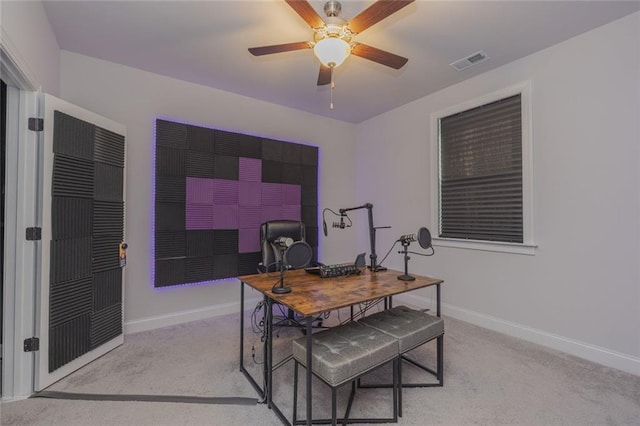 office featuring carpet floors, a ceiling fan, visible vents, and baseboards