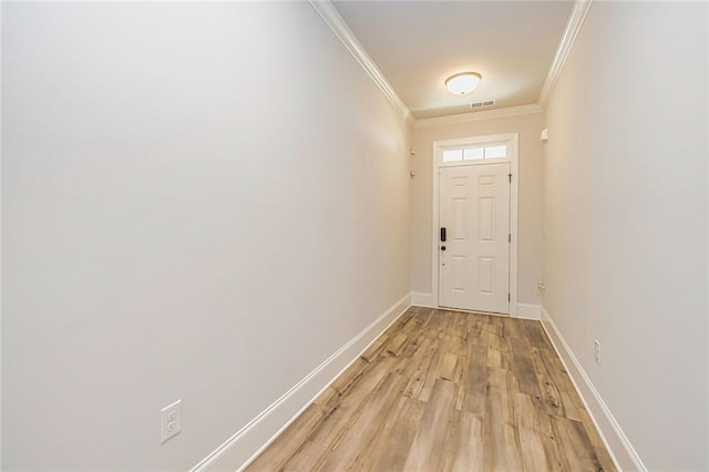 doorway to outside featuring light wood-type flooring, visible vents, baseboards, and crown molding