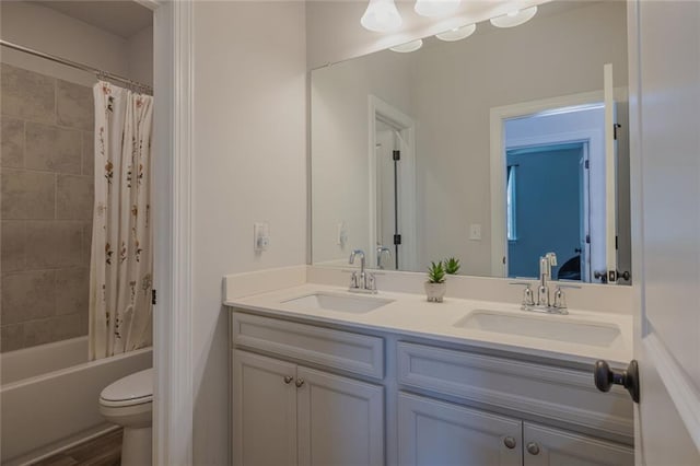 full bathroom with double vanity, shower / bathtub combination with curtain, toilet, and a sink