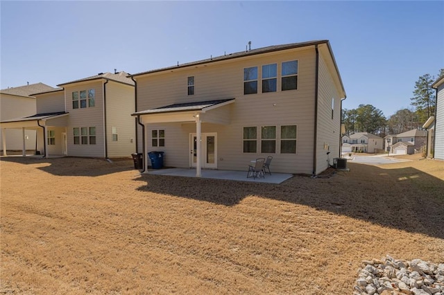 back of property with central AC unit and a patio area