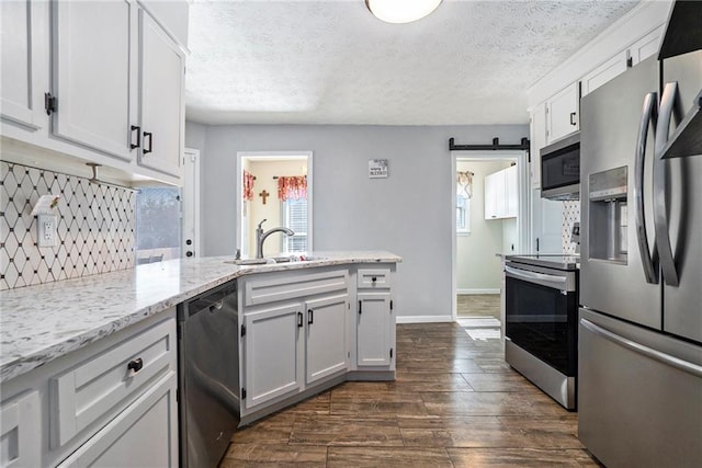 kitchen featuring tasteful backsplash, appliances with stainless steel finishes, sink, and white cabinets