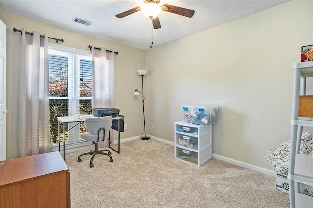 carpeted home office featuring ceiling fan