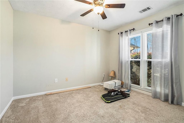 unfurnished room featuring ceiling fan and carpet flooring