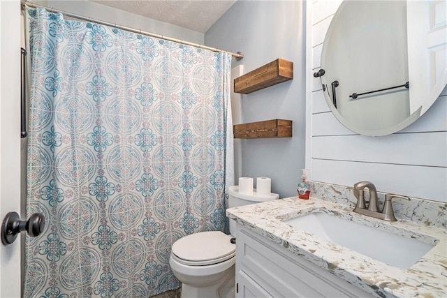 bathroom with vanity, a textured ceiling, and toilet