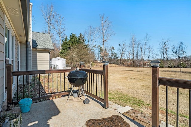 view of patio / terrace featuring a wooden deck, area for grilling, and a storage unit