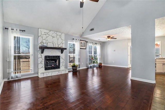 unfurnished living room with a stone fireplace, high vaulted ceiling, ceiling fan, and hardwood / wood-style flooring