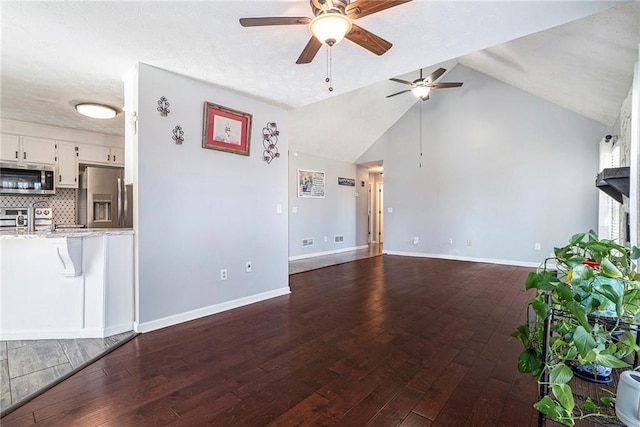 unfurnished living room with ceiling fan, lofted ceiling, and dark hardwood / wood-style flooring