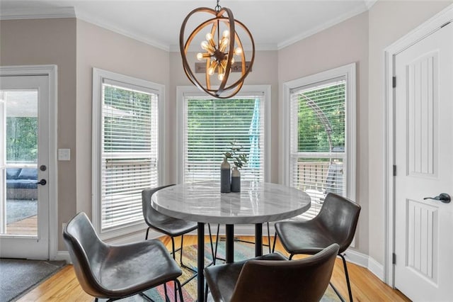 dining room featuring plenty of natural light, light wood-style flooring, crown molding, and an inviting chandelier