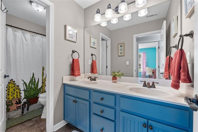 bathroom featuring double vanity, toilet, visible vents, and a sink